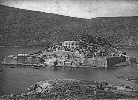 Le port sud de Spinalonga en 1897. </p> <em>L’île est alors habitée par des Turco-Crétois qu’on qualifie de pirates. À terre, on devine la douane turque ainsi que des habitations qui seront démolies par la suite.</em>